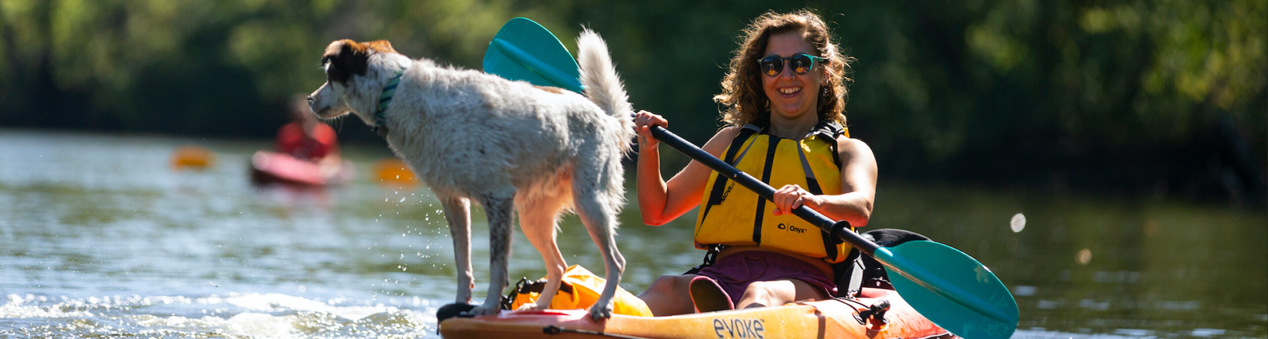 A person kayaking with their dog.
